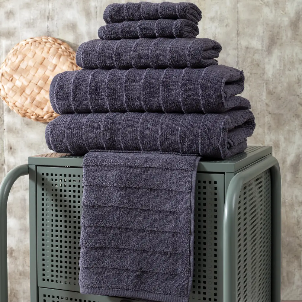 Charcoal Elegance towels stacked on a green stool