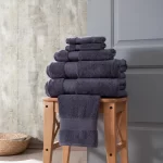 Charcoal Hotel Collection towel set on a wooden stool