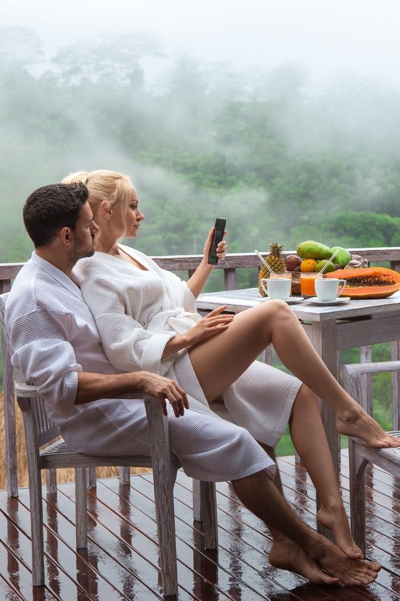 Couple relaxing on a balcony in white waffle pique spa robes