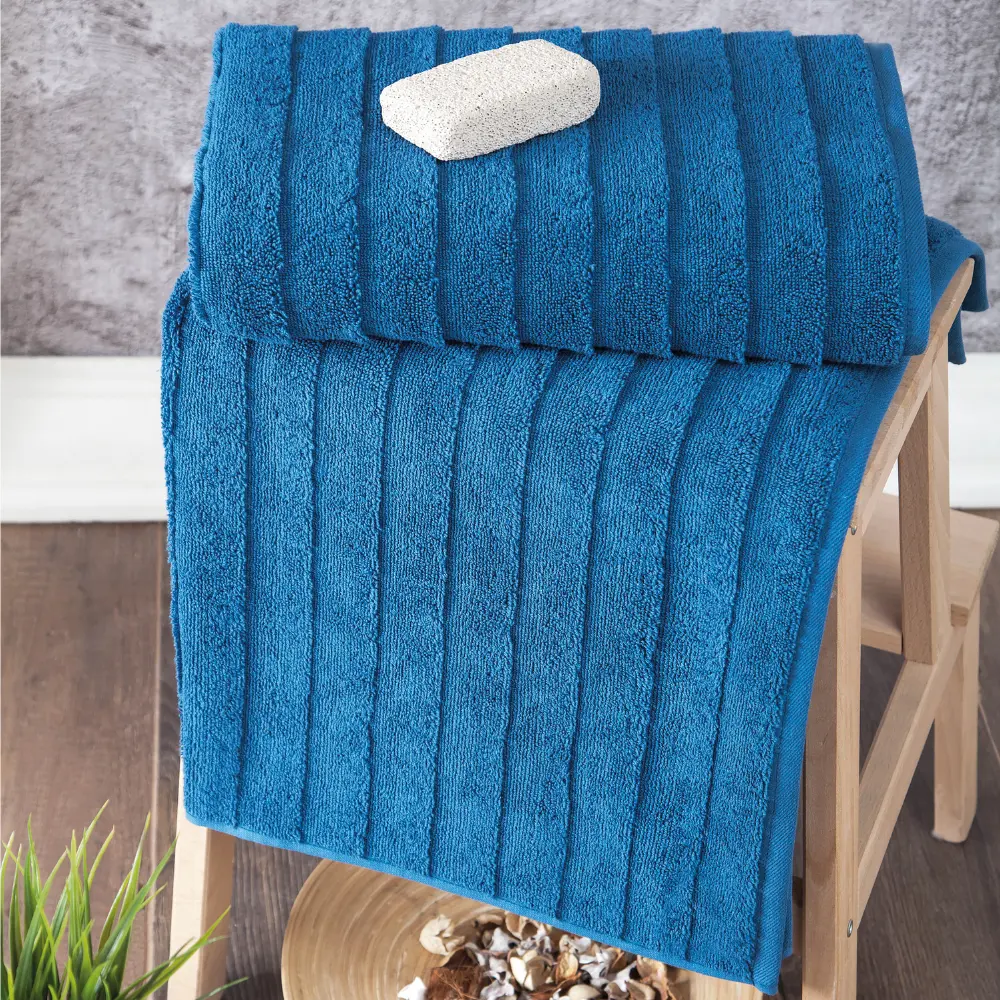 Close-up of the ribbed ladder-stripe weave on a petrol blue Bagno Milano Elegance towel