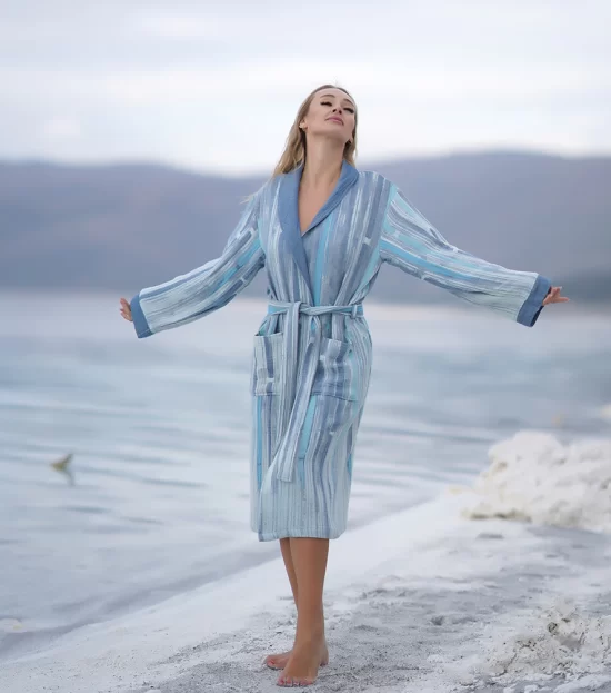 Woman in the Maia Peshtemal Bathrobe with arms open on the beach