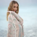 Woman wrapped in the beige Rigel Peshtemal Towel by the sea