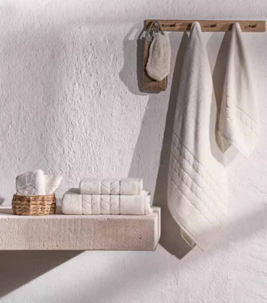 Cream organic jacquard border towels hanging in a bathroom