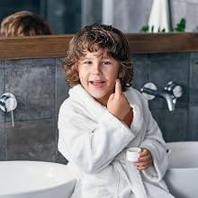 Child in white Organic Kids Robe brushing teeth in the bathroom - Bagno Milano