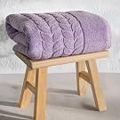 Folded lavender jacquard border towel on a wooden stool - Bagno Milano