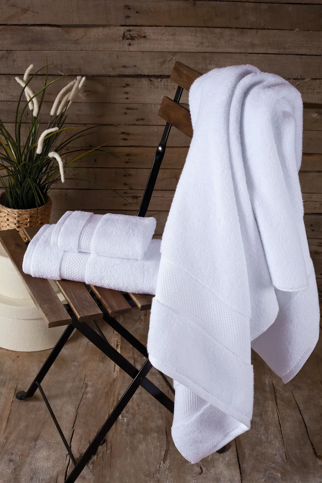 White Bagno Milano Hotel Collection towels draped on a wooden chair