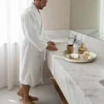 Man wearing white Organic Turkish Cotton Terry Kimono Bathrobe in a marble bathroom