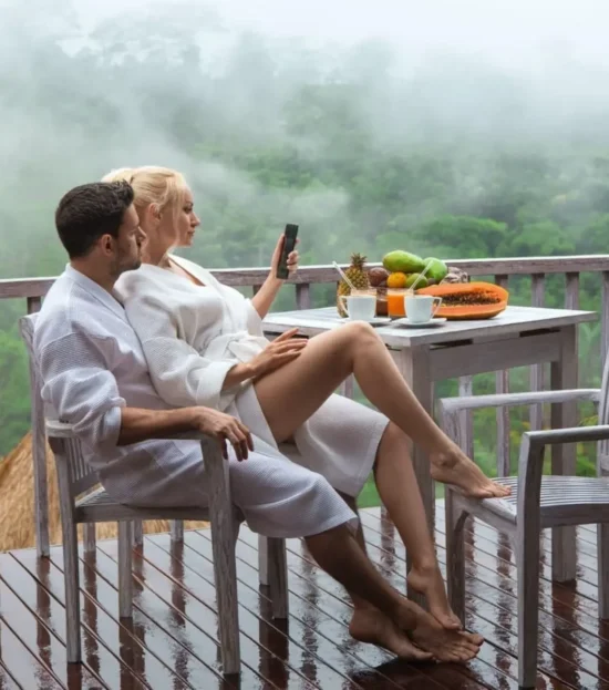 Couple wearing white waffle pique spa robes on a balcony