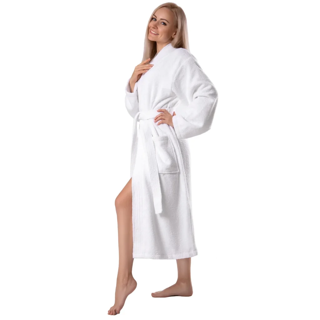 Side view of a woman in a white terry cotton robe with a patch pocket and self-tie belt